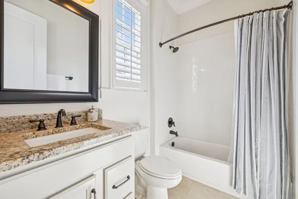 a kitchen with granite countertop a sink a stove and cabinets