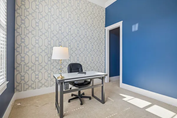 a view of an empty room with window and a kitchen