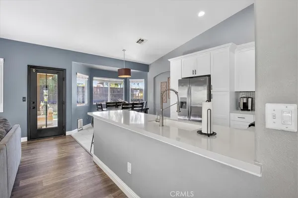 a view of a hallway with wooden floor and furniture