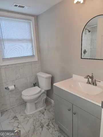 a bathroom with a toilet sink and mirror