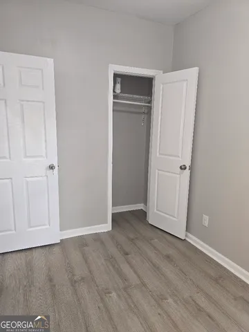 an empty room with wooden floor and closet