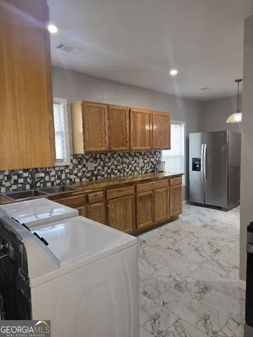 a kitchen with stainless steel appliances a sink and a refrigerator