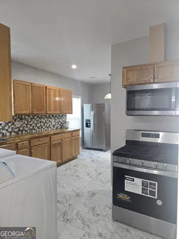 a kitchen with stainless steel appliances a stove a sink and a microwave
