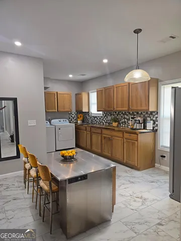 a kitchen with stainless steel appliances granite countertop a stove a sink a refrigerator and a wooden cabinets