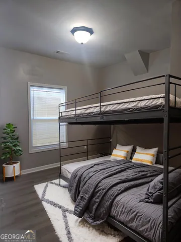 a bedroom with a bed and wooden floor