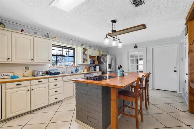 a kitchen with stainless steel appliances granite countertop table chairs sink and cabinets