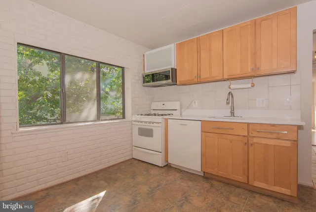 a kitchen with granite countertop white cabinets and white appliances