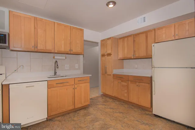 a kitchen with stainless steel appliances granite countertop a refrigerator sink stove and cabinets