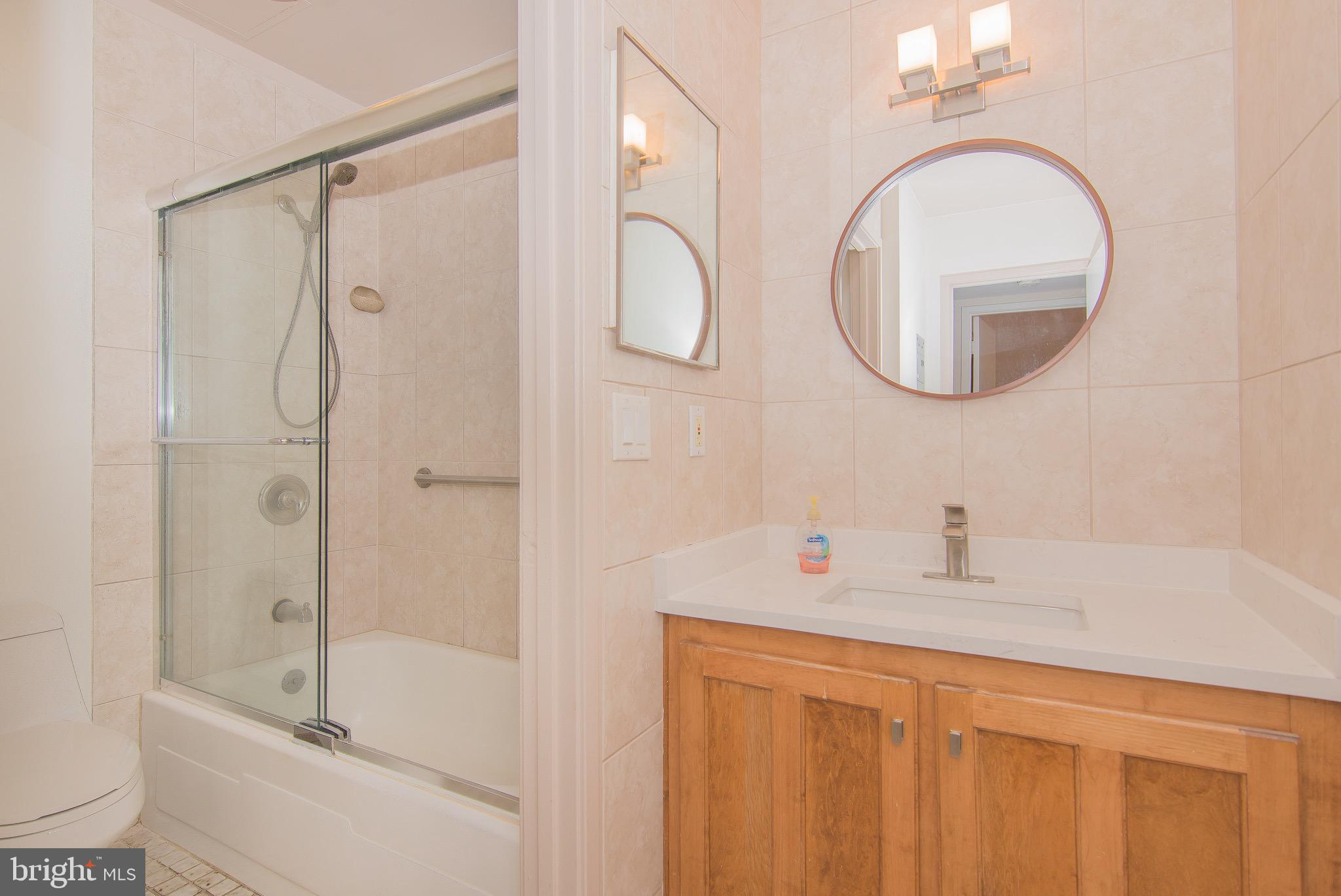 1665 Parkcrest Circle, Unit 301 Reston, VA 20190 - Photo 16 of 30 a bathroom with a sink a mirror a bathtub and shower