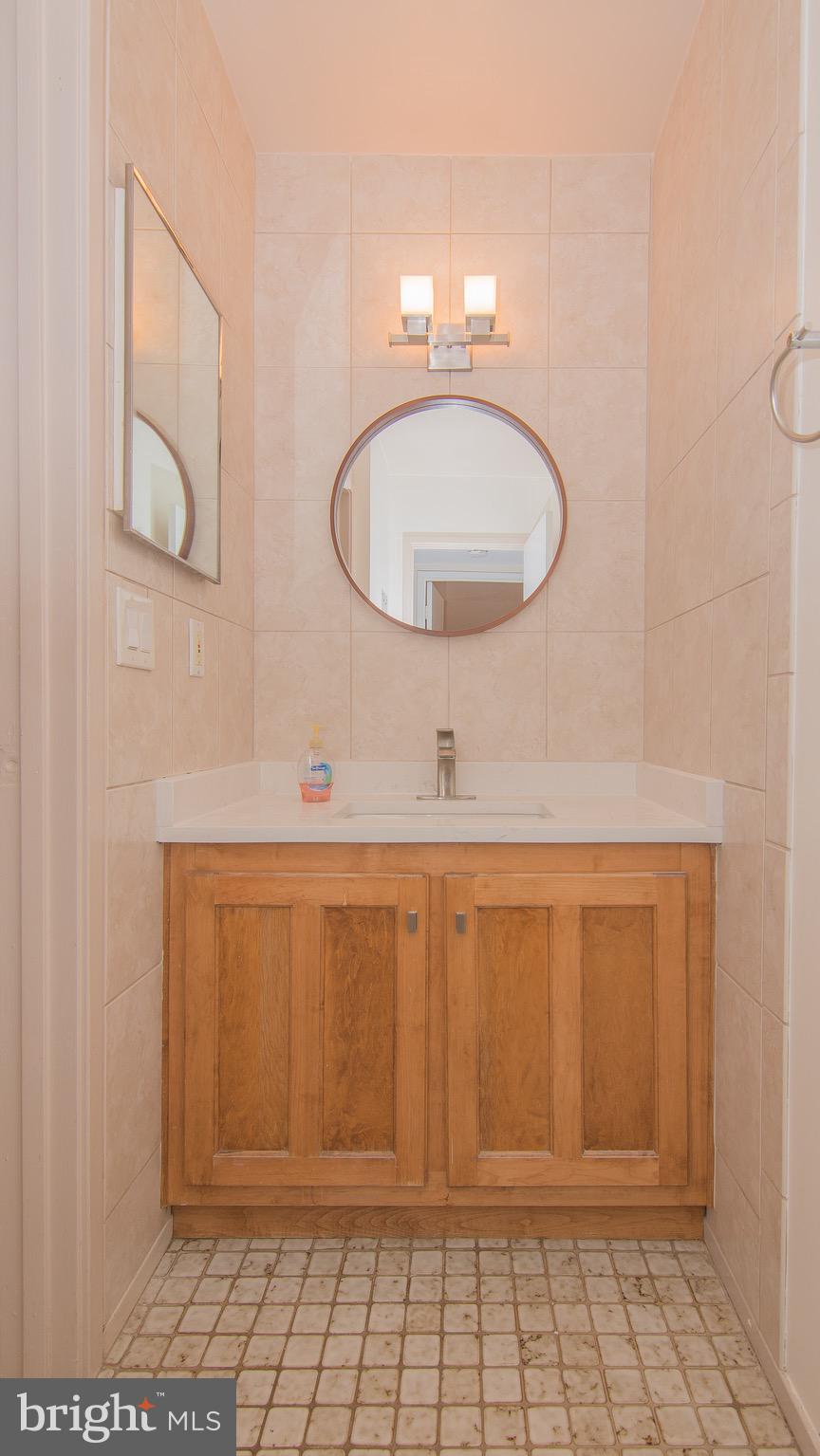 1665 Parkcrest Circle, Unit 301 Reston, VA 20190 - Photo 17 of 30 a bathroom with a sink a mirror and vanity