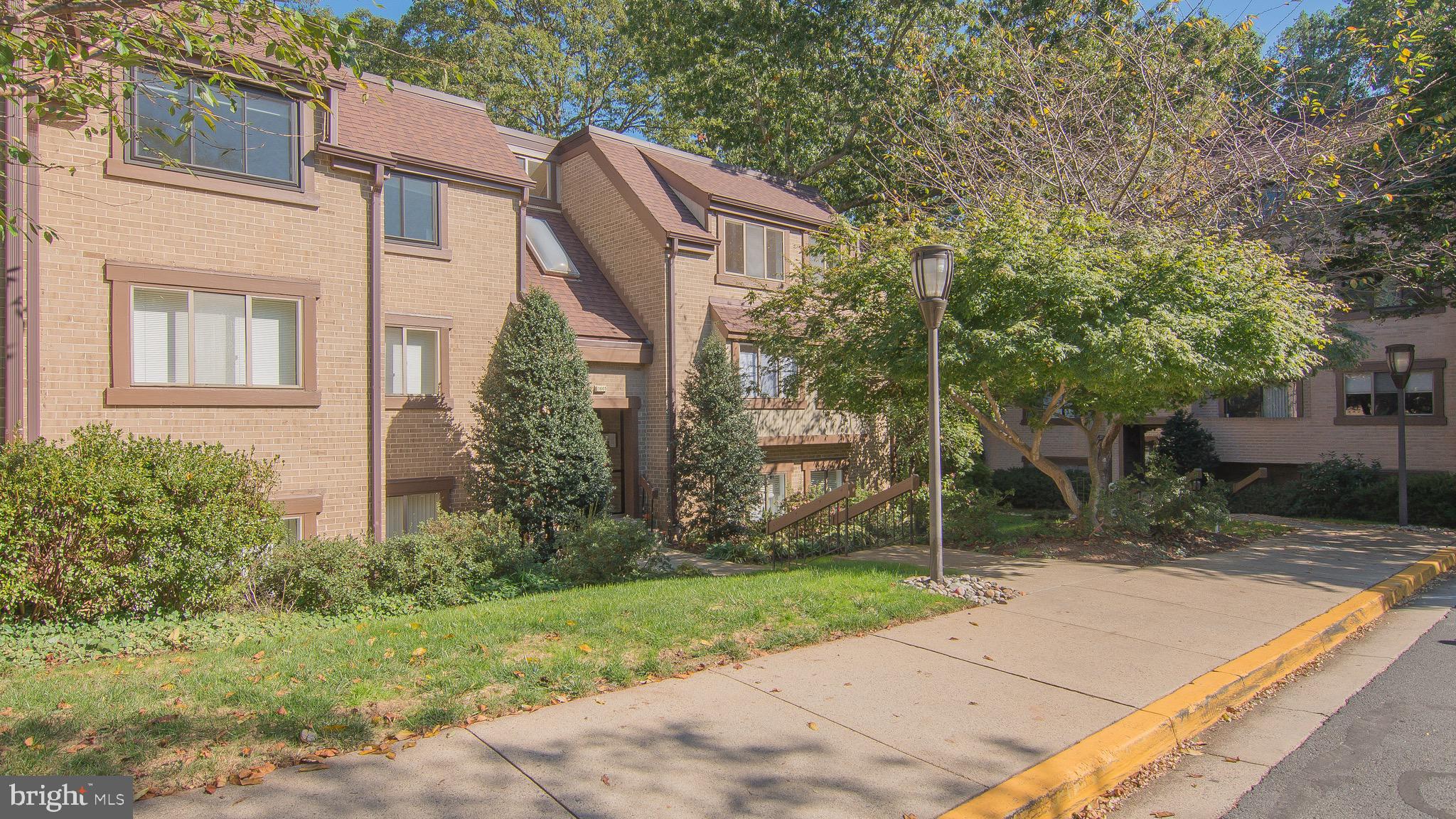 1665 Parkcrest Circle, Unit 301 Reston, VA 20190 - Photo 29 of 30 a view of a house with brick walls plants and large tree