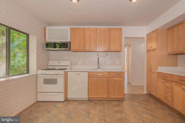 a kitchen with granite countertop white cabinets and white appliances