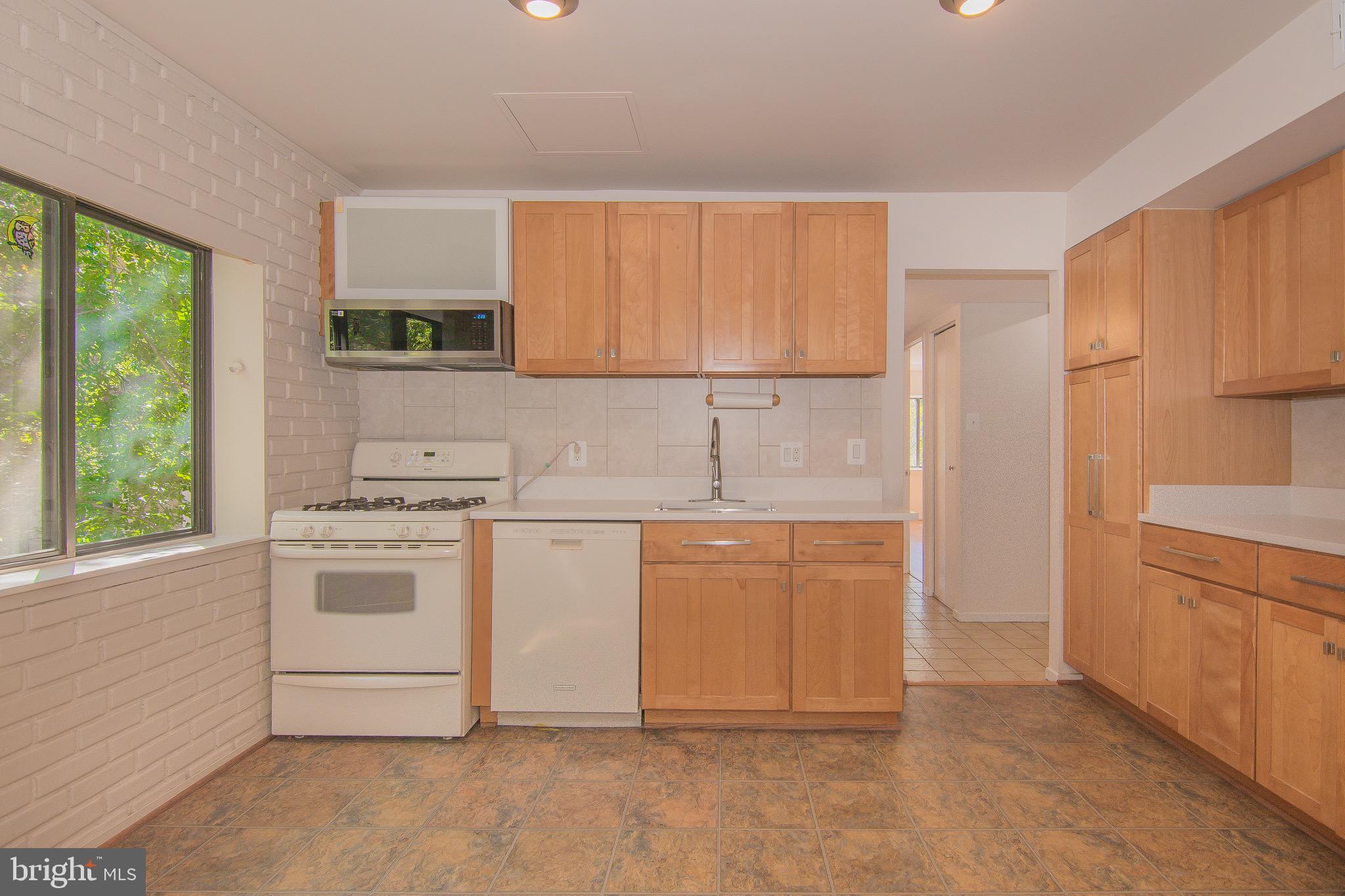 1665 Parkcrest Circle, Unit 301 Reston, VA 20190 - Photo 10 of 30 a kitchen with granite countertop white cabinets and white appliances