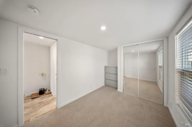 an empty room with windows and closet