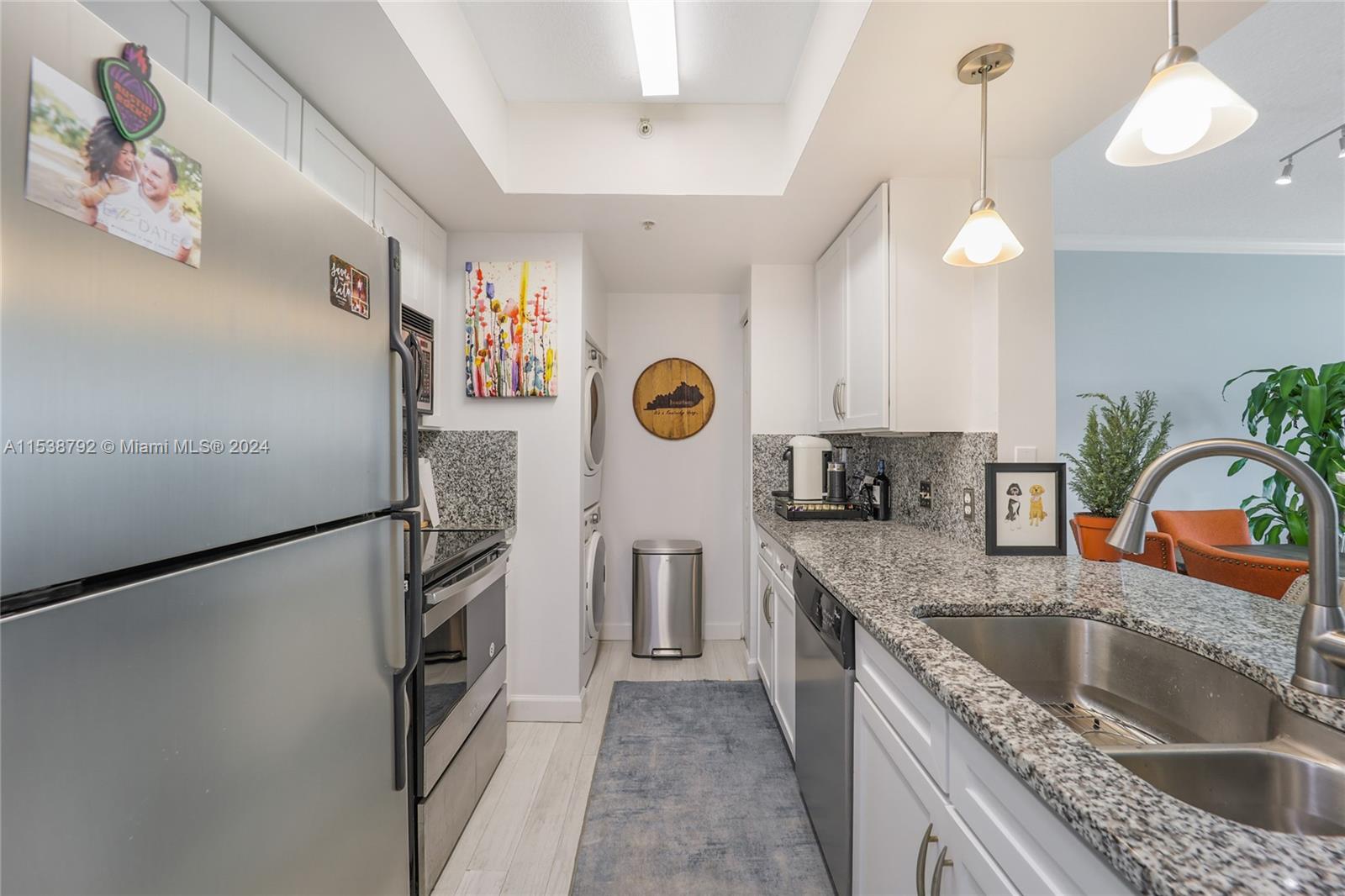 a kitchen with stainless steel appliances granite countertop a refrigerator a oven and a sink