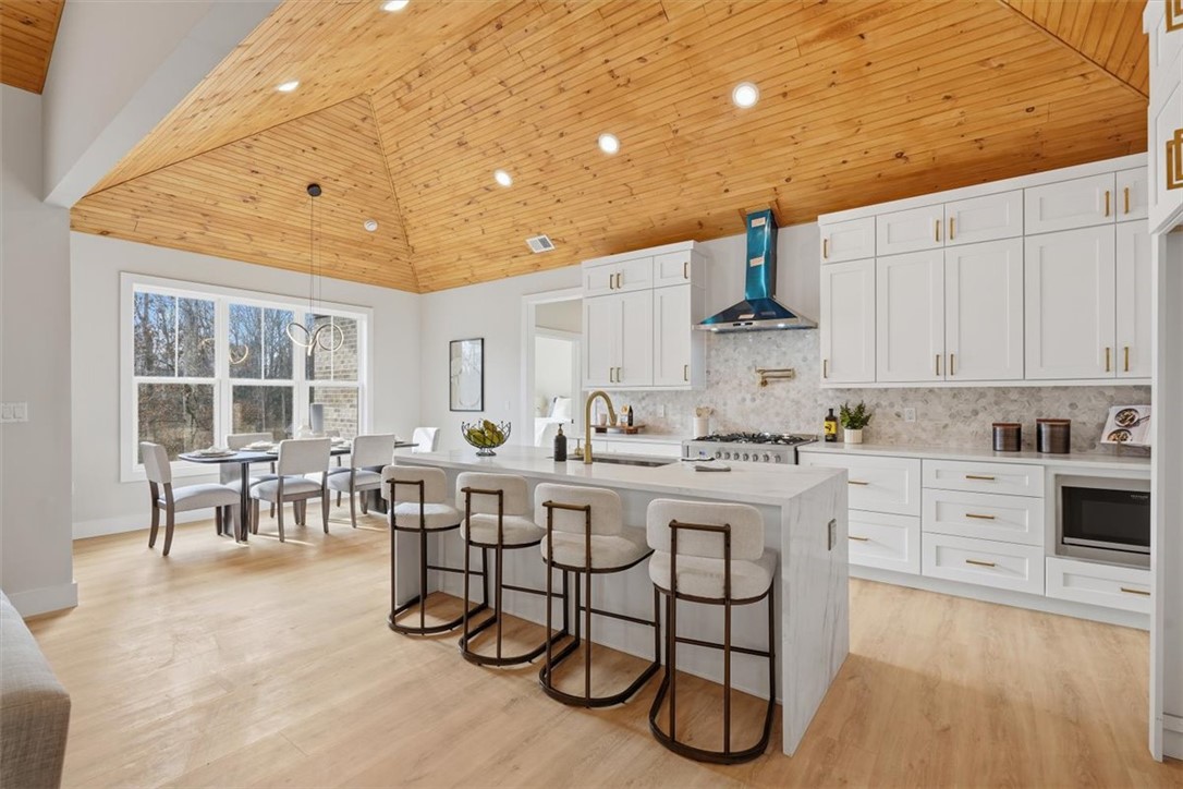 304 Avenue Of Oaks Anderson, SC 29621 - Photo 12 of 38 This kitchen and dining area features a spacious layout with vaulted wood ceilings and modern amenities.