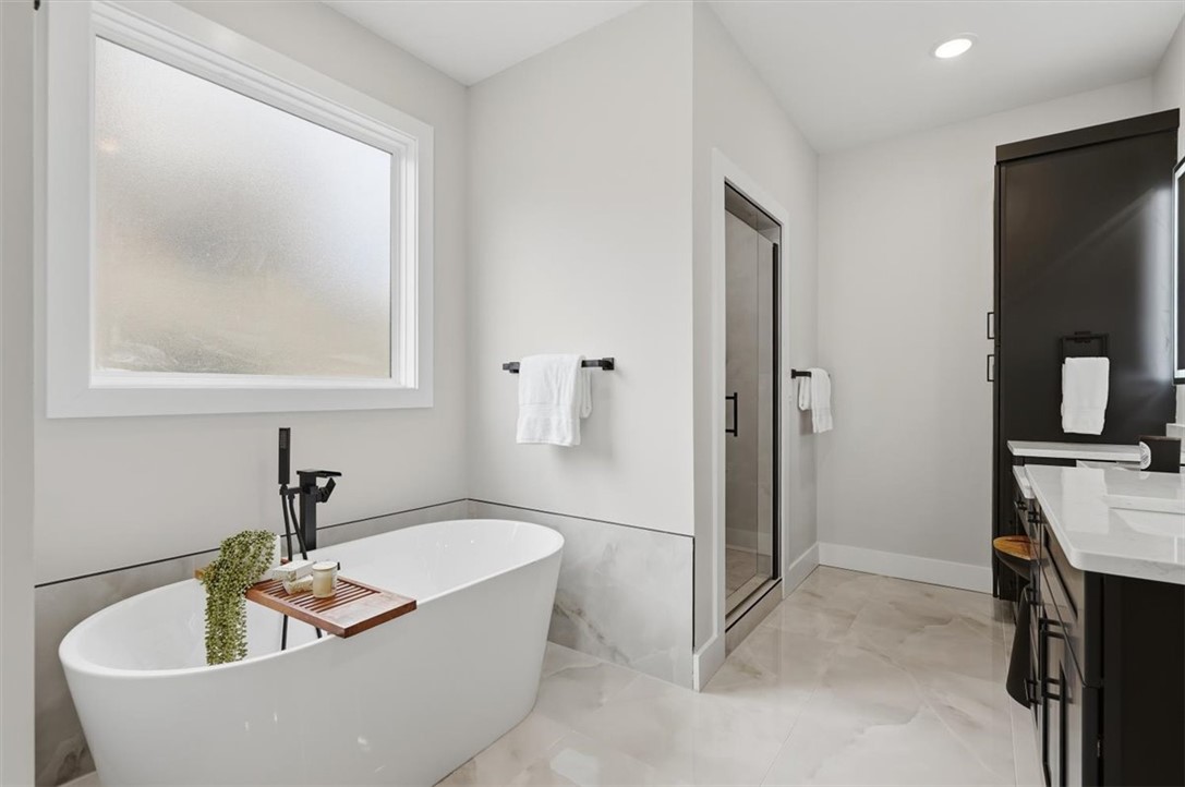 304 Avenue Of Oaks Anderson, SC 29621 - Photo 23 of 38 This modern bathroom features a freestanding tub, glass-enclosed shower, and sleek vanity with ample storage.