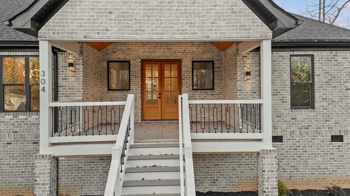 304 Avenue Of Oaks Anderson, SC 29621 - Photo 30 of 38 This charming home features a classic brick exterior, inviting porch, and sturdy railing.