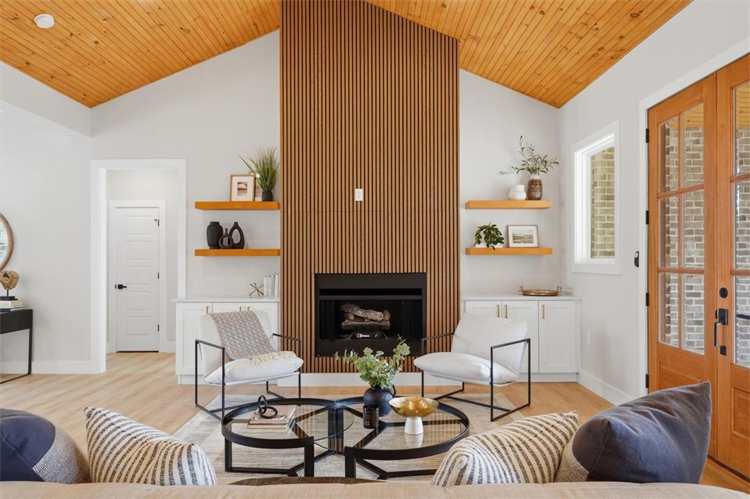 304 Avenue Of Oaks Anderson, SC 29621 - Photo 5 of 38 Bright and airy living area with a captivating fireplace and warm wooden ceiling accents.