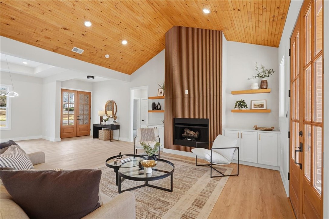 304 Avenue Of Oaks Anderson, SC 29621 - Photo 6 of 38 This bright living space features wood flooring and an inviting fireplace, perfect for relaxation.