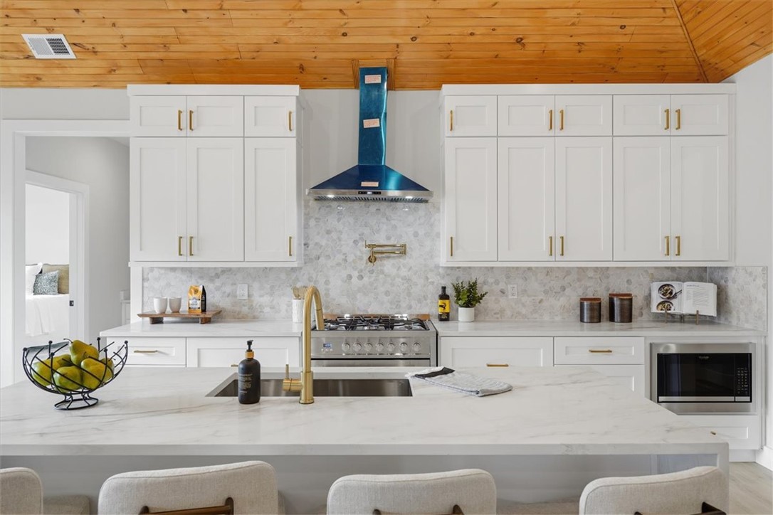 304 Avenue Of Oaks Anderson, SC 29621 - Photo 10 of 38 This bright kitchen features wood ceilings, ample cabinetry, and sleek appliances for modern living.