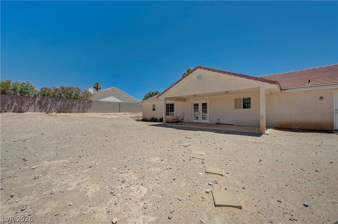 1272 Liston Avenue Logandale, NV 89021 - Photo 47 of 61 An arid backyard with a covered patio area and stepping stones leading to the home's double French doors.