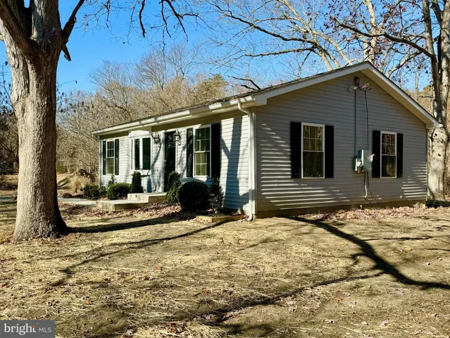 a view of a house with snow on the side of the road