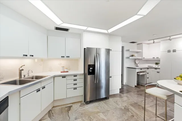 a kitchen with white cabinets and stainless steel appliances