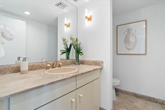a bathroom with a granite countertop sink and a mirror