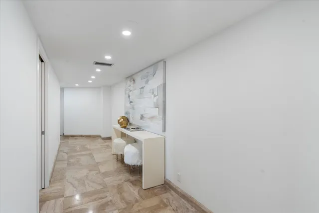 a view of a hallway with two chair and a potted plant