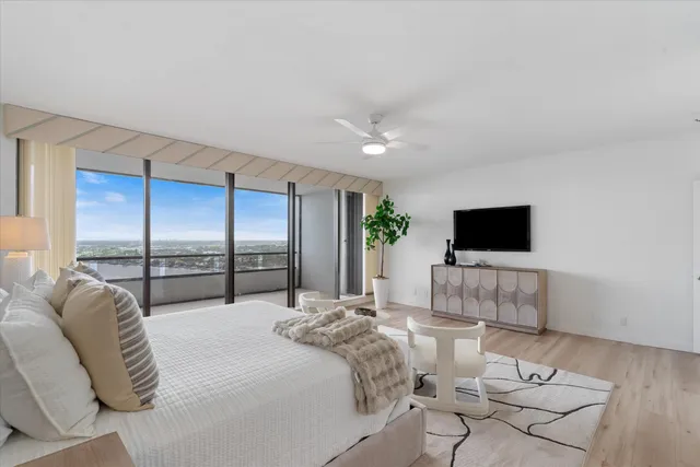 a bedroom with a bed a flat screen tv and a couch