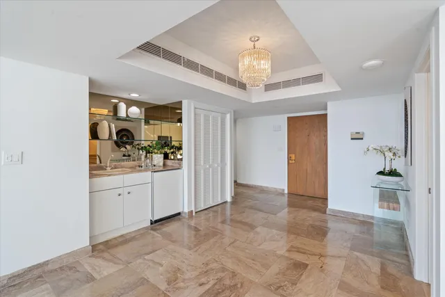 a view of a hallway to a bedroom and a chandelier