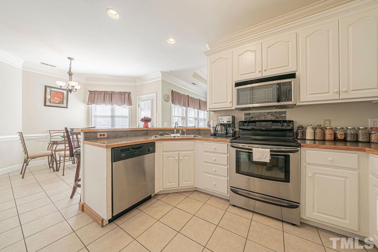 11563 Rockside Road Middlesex, NC 27557 - Photo 19 of 53 a kitchen with stainless steel appliances granite countertop a stove a sink and a microwave
