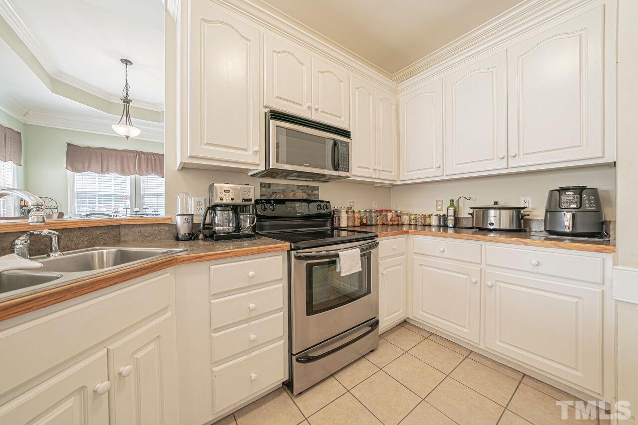 11563 Rockside Road Middlesex, NC 27557 - Photo 20 of 53 a kitchen with white cabinets stainless steel appliances and sink