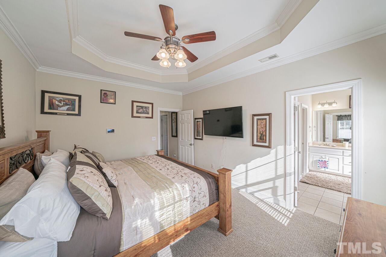 11563 Rockside Road Middlesex, NC 27557 - Photo 32 of 53 a bedroom with a large bed a flat screen tv and a dresser