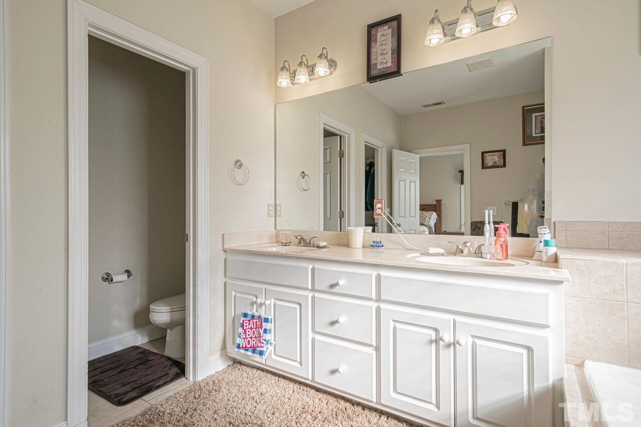 11563 Rockside Road Middlesex, NC 27557 - Photo 33 of 53 a spacious bathroom with a sink a toilet a shower and a mirror