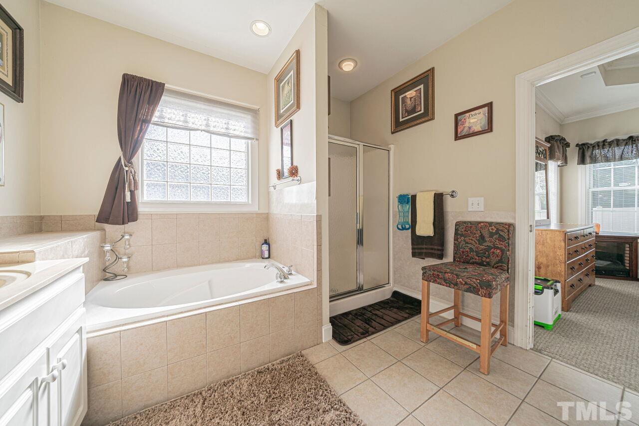11563 Rockside Road Middlesex, NC 27557 - Photo 35 of 53 a bathroom with a granite countertop tub shower and sink
