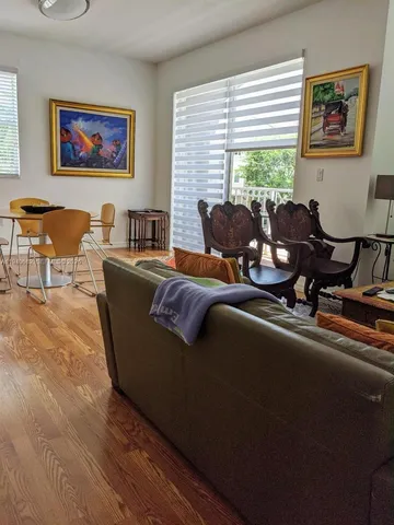 a living room with furniture two window and a flat screen tv