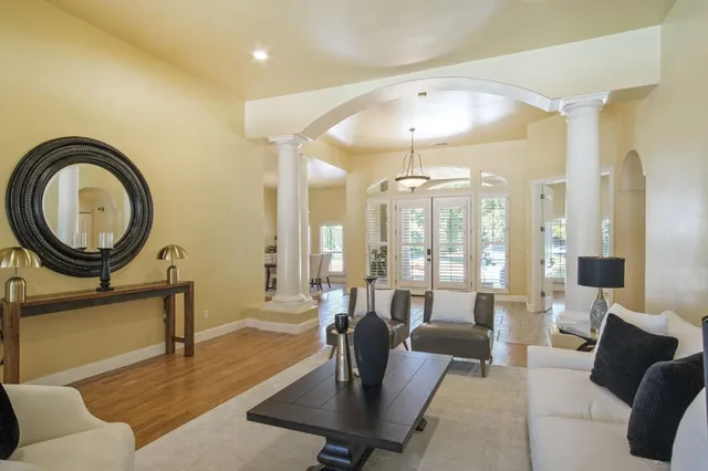 a living room with furniture a large window and a chandelier