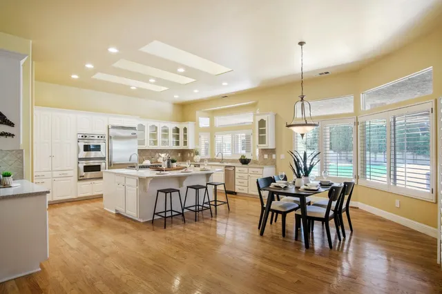 a view of a dining room and livingroom with furniture wooden floor a chandelier