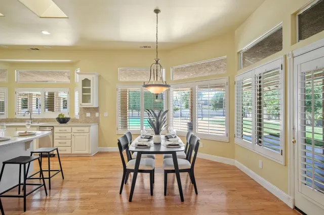 a dining room with furniture a chandelier and wooden floor