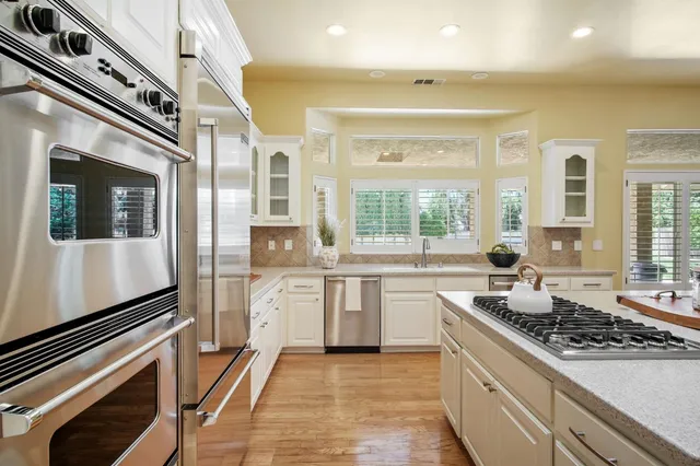 a large kitchen with stainless steel appliances granite countertop a stove and a sink