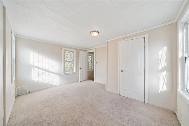 a view of empty room with windows and wardrobe