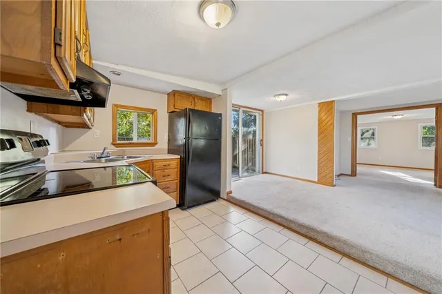 a kitchen with a refrigerator a stove top oven and a sink