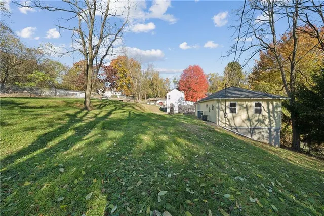 a view of a house with a yard and tree