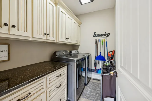 a kitchen with white cabinets and clock on the wall