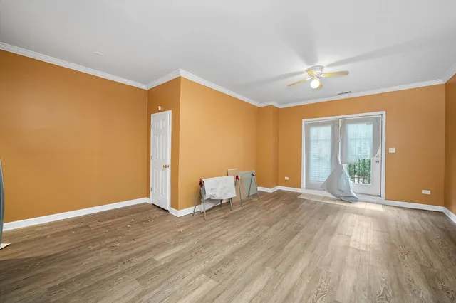 a view of an empty room with glass door and a window