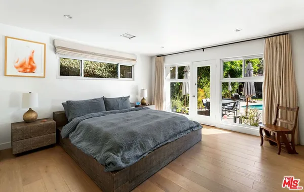a spacious bedroom with a bed and glass walk in closet
