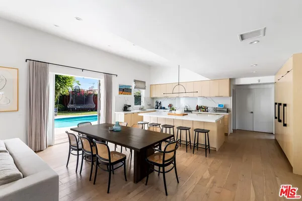 a dining room with a table chairs and a kitchen view
