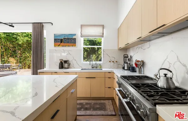 a kitchen with a stove a sink and a window
